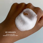 Text (Key Highlights - Moisturize Skin - Suitable for sensitive skin) over image of foaming face wash on hand. 