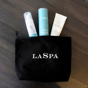 3 products (LASPA Mineral sunscreen, foaming facial wash, Glycolic Peel (10%) in black LASPA makeup bag. 